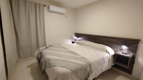 a bedroom with a large bed with a wooden headboard at Vid_y_Olivo. Cómodo departamento en el centro de Maipú in Maipú
