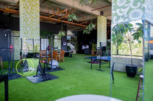 a room with green grass and tables and chairs at Azumi Boutique Hotel in Manila