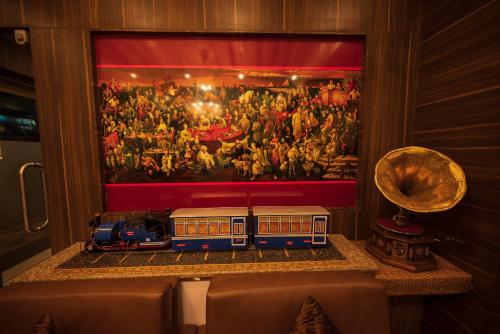 a toy train on a table in front of a painting at Rajdarbar Hotel & Banquet, Siliguri in Siliguri