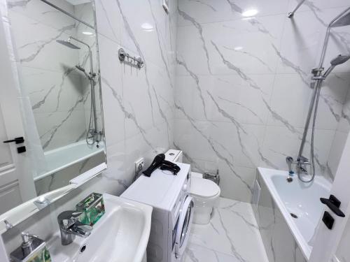 a white bathroom with a toilet and a sink at ЖК «Комфорт Сити» in Almaty