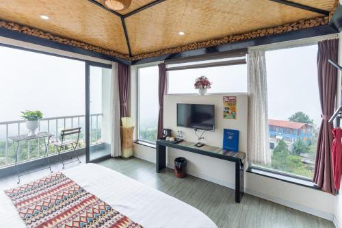 a bedroom with a bed and large windows at Phuong Nam Hotel in Sapa