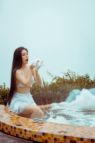 a woman sitting on a surfboard in the water at Phuong Nam Hotel in Sa Pa