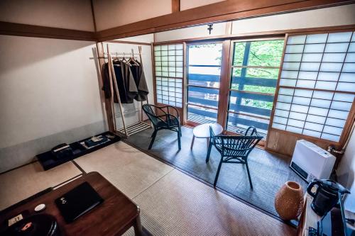a room with two chairs and a table and some windows at Hacho no Yu in Nikko