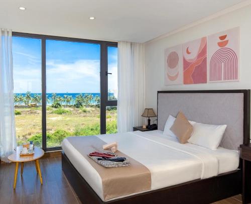 um quarto com uma cama e vista para o oceano em KIKOZO DA NANG Hotel em Da Nang