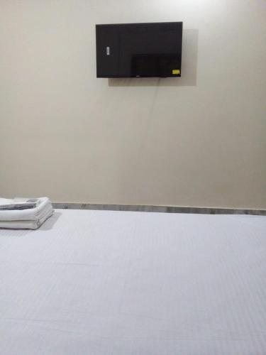 a room with a flat screen tv on a wall at Gaur Homestay AC Rooms in Puri