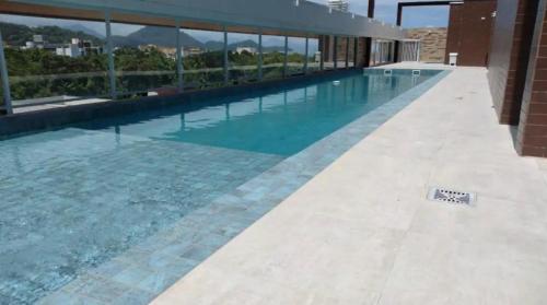 a swimming pool with blue water in a building at Ap. c/ piscina 400m praia in Ubatuba