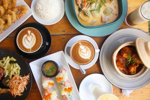 a table with plates of food and cups of coffee at Sea View Resort in Siquijor