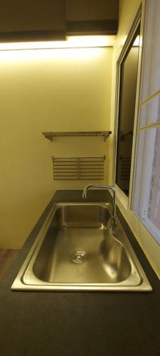 a stainless steel sink in a kitchen with a window at Lanmuanghouse in Chiang Rai