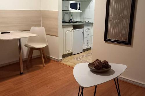 een kleine keuken met een tafel en stoelen en een tafel bij Apart hotel en el corazon de Providencia,Stgo in Santiago