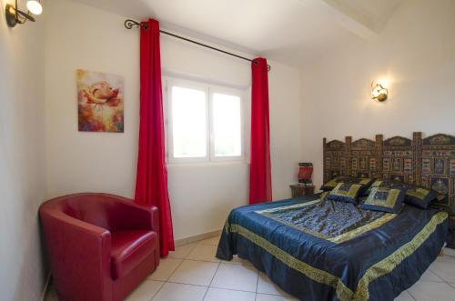 a bedroom with a bed and a red chair at Luxueuse Villa - Golfe de St Tropez in Sainte-Maxime