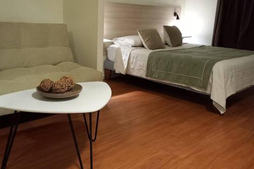 een slaapkamer met een bed, een tafel en een bank bij Apart hotel en el corazon de Providencia,Stgo in Santiago