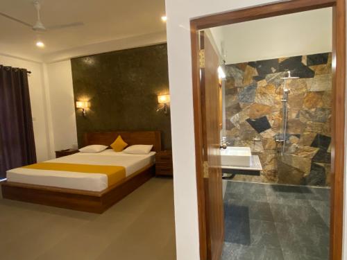 a bedroom with a bed and a bathroom with a shower at Lina Hotel in Habarana