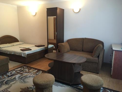- un salon avec un canapé, une table et un lit dans l'établissement Номера та Паркінг- Rooms & Parking, à Tchernivtsi
