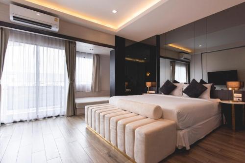 um quarto grande com uma cama grande e um sofá em Qlosest Hotel em Nakhon Ratchasima