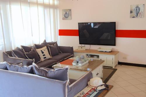 a living room with couches and a flat screen tv at The Lighthouse Ocotal in Coco