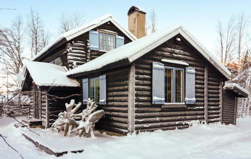 una cabaña de madera en la nieve con una estatua delante en Vemdalsskalsgården en Vemdalen