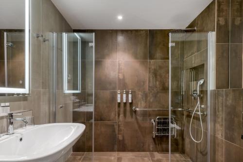 a bathroom with a shower and a tub and a sink at AC Hotel Venezia by Marriott in Venice