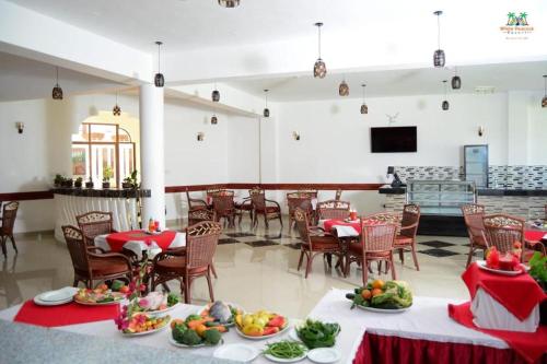 a banquet hall with tables and chairs with food on them at White Peacock Resort Mtwapa in Mtwapa