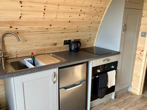 a kitchen with a sink and a counter top at Waterpump Pod for 2 adults with ensuite in the Suffolk Countryside in Badingham