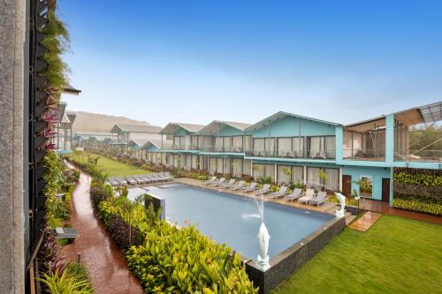 an exterior view of a resort with a pool and a fountain at TAN-N-SAND in Morjim