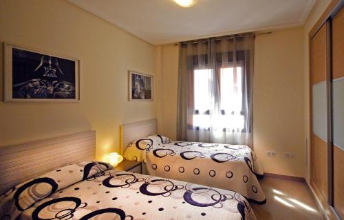 Un dormitorio con dos camas y una ventana en Apartment De Jardines, en Denia
