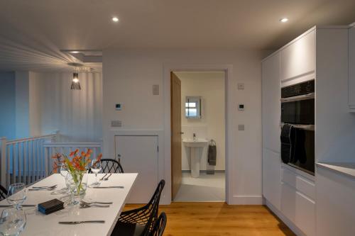 a dining room with a white table and chairs at Lanyon in St Ives