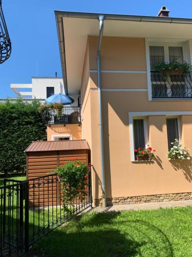 a building with a fence next to a house at Horváth Apartman in Balatonlelle