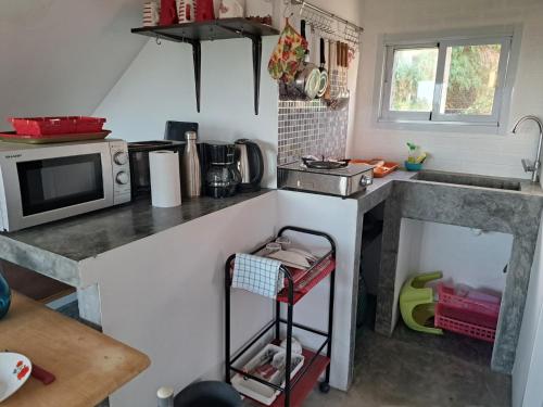 uma pequena cozinha com um balcão e um micro-ondas em Juliet Home Samui em Ban Lamai