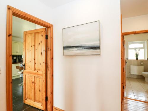 a door leading into a bathroom with a picture on the wall at Coorlacka in Ballydivin