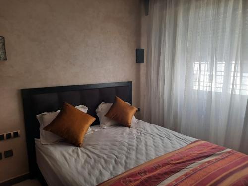 a bedroom with a bed with pillows and a window at MAZAPART in El Jadida