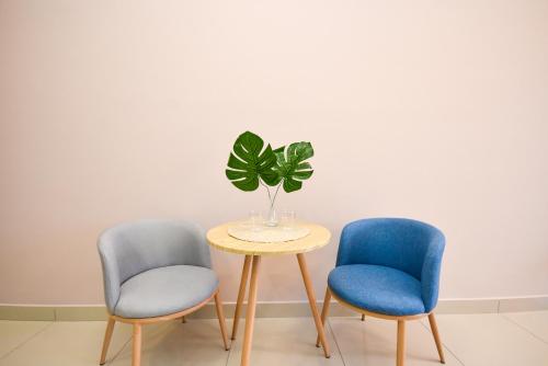 three chairs and a table with a plant on it at Twin Tower Residence by Nest Home【5 mins walk to CIQ】 in Johor Bahru