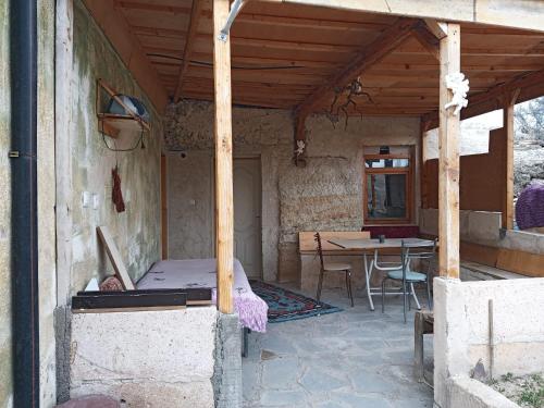 eine Veranda eines Hauses mit einem Bett und einem Tisch in der Unterkunft KIR EVI/BAG EVI 