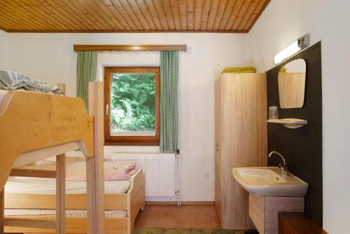 - une petite chambre avec des lits superposés et un lavabo dans l'établissement Flying Hirsch, à Stall