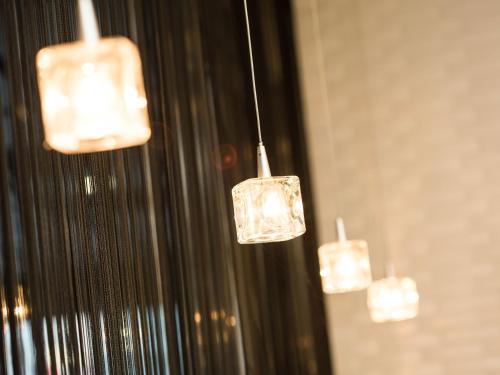 a group of lights hanging from a wall at Hotel AreaOne Okayama in Okayama