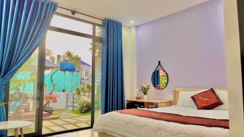 Cu Lao ThuにあるVila Ánh Dươngのベッドルーム1室(ベッド1台付)、スライド式ガラスドアが備わります。