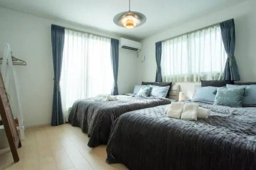 sypialnia z 2 łóżkami i oknem w obiekcie 青の洞窟and恩納村YAMADA w mieście Yamada