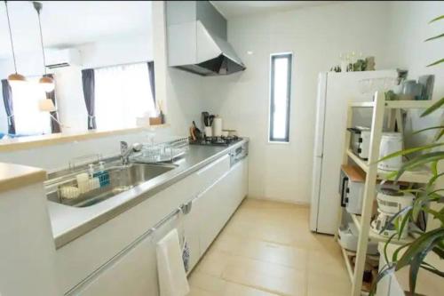 a kitchen with a sink and a refrigerator at 青の洞窟and恩納村YAMADA in Yamada