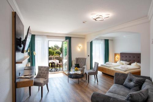 - un salon avec un canapé et un lit dans l'établissement Gräfliches Hotel Alte Post, à Bad Birnbach