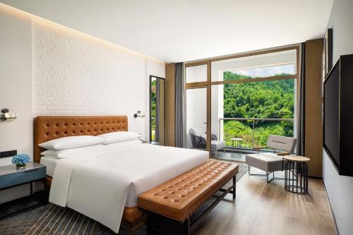 a bedroom with a large bed and a large window at Four Points by Sheraton Qiandao Lake in Thousand Island Lake