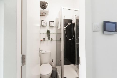 Un baño blanco con inodoro y ducha. en Cosy Central Studio Apartment Zone 2 (4), en Londres