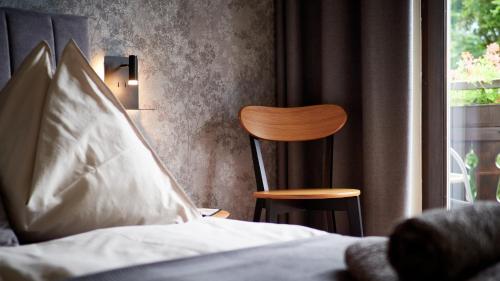 a bedroom with a bed and a chair and a window at Jeff's - Rooms with a mountain view in Bad Goisern