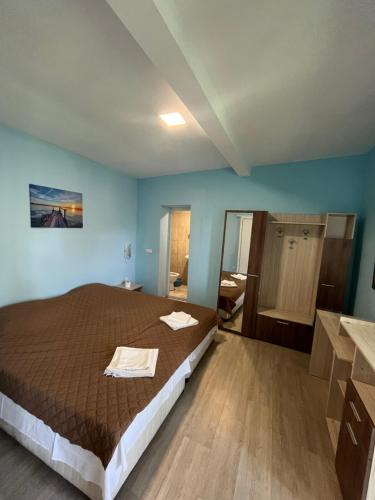 シャブラにあるShabla Lux Guest Housesのベッドルーム(大型ベッド1台付)、バスルームが備わります。