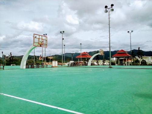 a green tennis court with a basketball hoop on it at Cozy Apartment 2 in Telipok Town