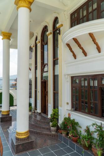 a building with columns and potted plants at The White House Villa 8 bedroom with Swimming Pool in Kathmandu