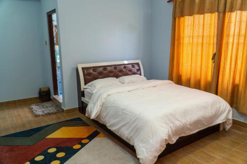 a bedroom with a large bed with white sheets at The White House Villa 8 bedroom with Swimming Pool in Kathmandu