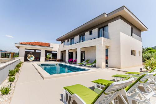 a villa with a swimming pool and chairs at Villa Bay View in Stari Grad