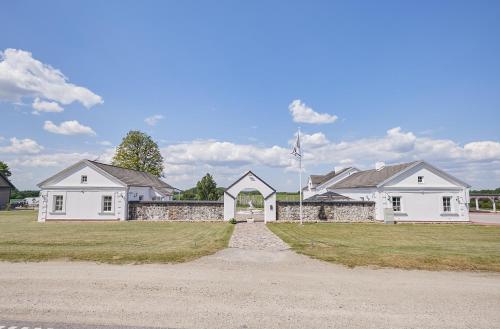 a large white house with a flag on top of it at Arklių Pašto Stotis 