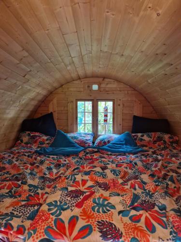 ein Schlafzimmer mit einem großen Bett in einem Blockhaus in der Unterkunft Chalet de la forêt 1 à 6 pers in Saint-Sauveur