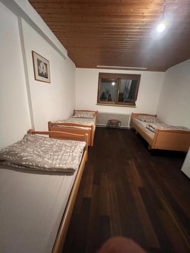 three beds in a room with wooden floors at Mira Home 2 in Murg