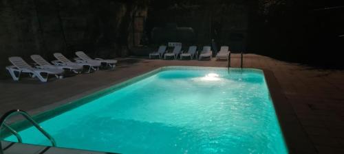 a swimming pool at night with lounge chairs and a pool at El Chisco in San Cosme